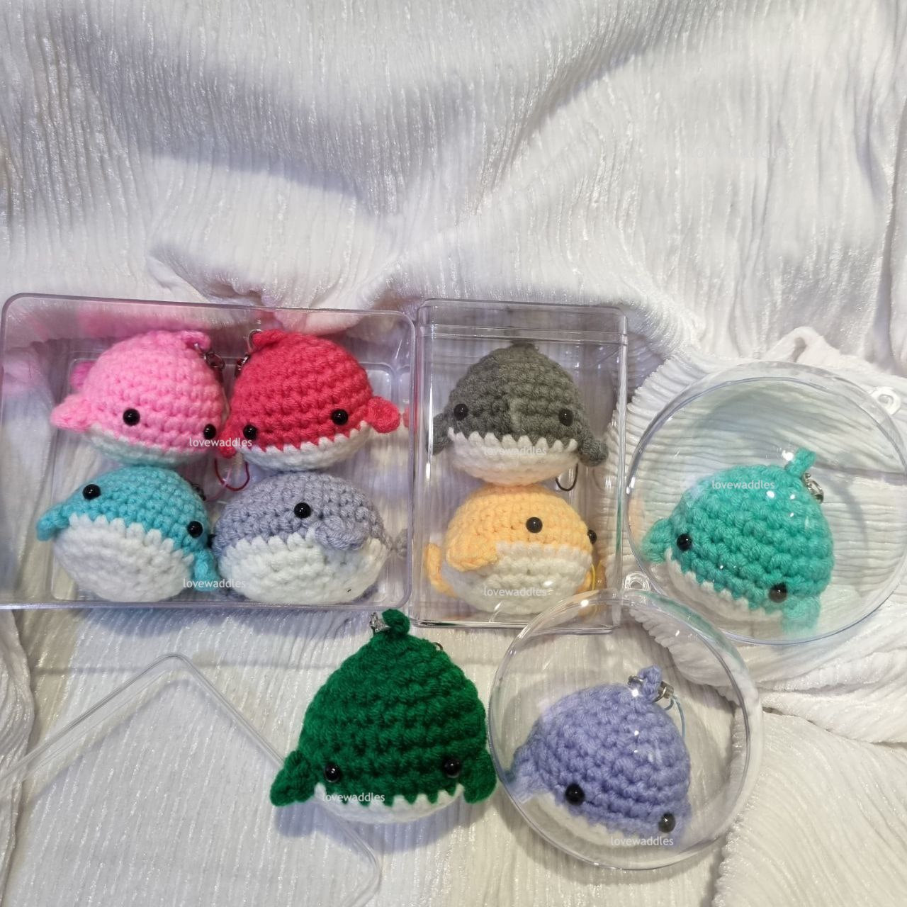 All acrylic cases displayed with crochet whales in it. 