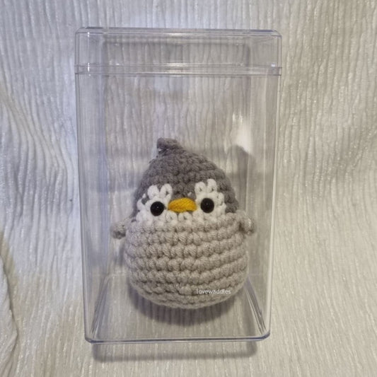 Crochet penguin in an acrylic box. 